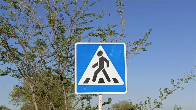 A pedestrian crossing sign on the road in close-up. Traffic Laws.