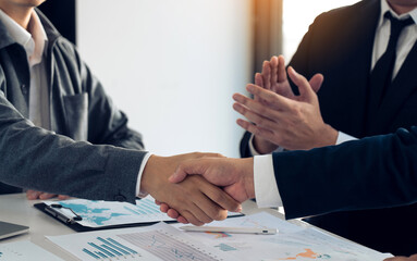 Businessmen shaking hands while completing work.