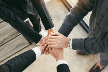 Close up of group of business people joining their hands together in unity.