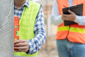 Fototapeta premium Contactor or engineer is inspecting construction and quality assurance new house using a level. Engineers or architects or contactor work to build the house before handing it over to the homeowner