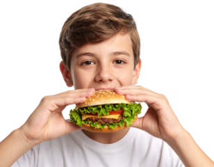 A young boy with brown hair holds a large, fresh hamburger with lettuce and tomato, ready to take a bite against a black background.