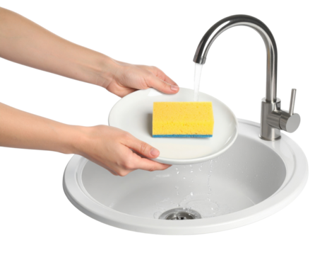 A person holds a white plate with a yellow sponge under a running kitchen faucet above a round sink.