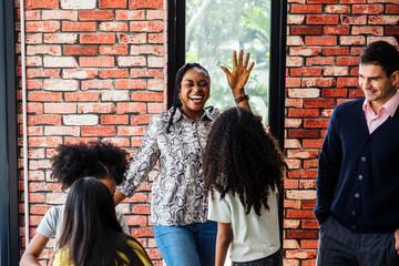 Group of kids and teachers celebrate success in a classroom after completing a robotics project. Joyful moment of teamwork, motivation, and achievement in a creative learning environment.