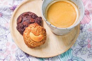 Coffee break with a cup of hot coffee and chocolate, nut cookies, served on a table. 