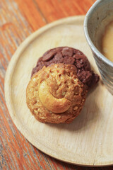 Coffee break with a cup of hot coffee and chocolate, nut cookies, served on a table. 