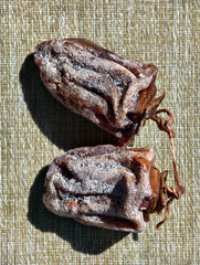 Dried persimmon fruits on the napkin. Topview of sweet dry fruits.