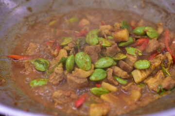 Spicy stir fried pork with Cluster Bean (Bitter Bean or stink beans) popular southern Thai food, Spicy stir fried chicken with Cluster Bean (Bitter Bean or stink beans).Thai southern food
