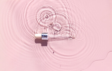 pipette serum in water on pink background ripples water drops natural sunlight