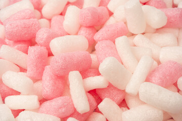 Pink and white box filler as a background. Top view.