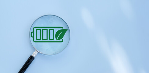 Green energy, Magnifying glass focus on battery, Sustainable living with renewable energy, Eco power