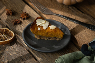 Slice of pumpkin pie sprinkled with sliced almonds. Homemade traditional American thanksgiving pie