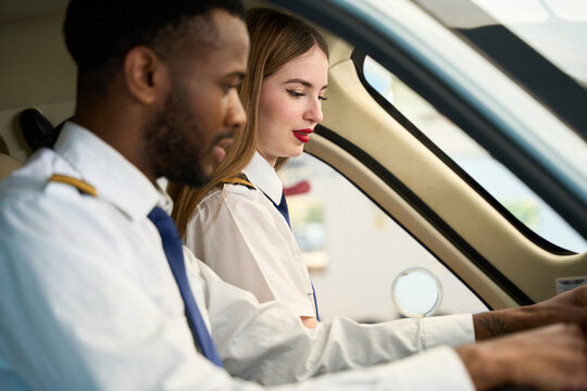 Student pilots training inside cockpit of small airplane