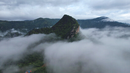 Aerial view of greenery mountains and rural village on foggy morning