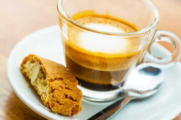 Macchiato coffee in the glass cup and piece of cake