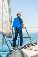 Boy on bow of sailboat on beautiful New Zealand day