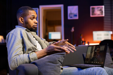 African american web user meeting with workmates on a video call remotely, ensuring a strong...