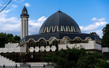 Modern mosque with distinctive architecture under bright blue sky during afternoon