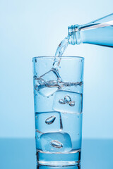 Crystal clear water being poured into a transparent glass, creating refreshing ripples and bubbles