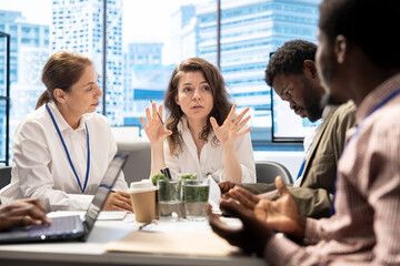 During a briefing meeting, general manager and his work team discussing budget forecasts and making...