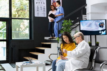Skilled physician gives advice and explanation of x ray scans to asian patient during a health...