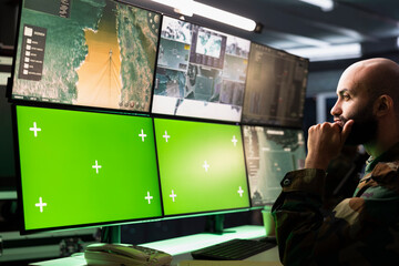 Counterterrorism division operative using target acquisition tech on mockup monitors to detect...