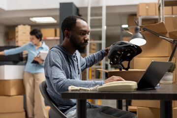 African american guy managing product handling and packing goods for distribution in a logistics...