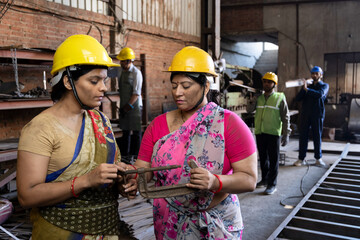 Confident industrial workers in protective workwear at factory