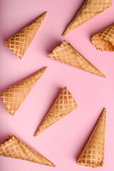 Multiple waffle cones arranged neatly on a pink backdrop highlight the variety of choices available for ice cream enthusiasts enjoying a sweet treat