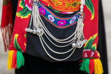 Close up accessories such as jewelry are attached or hung on the traditional costumes of the Tay...