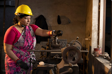 Indian female engineers are operating lathes in the workshop.