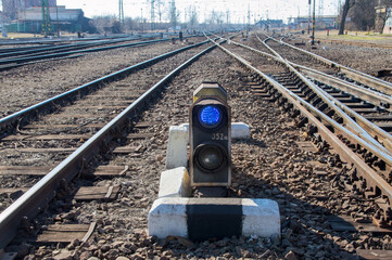 railway switch light with blue signal on tracks

