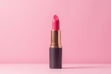 A single pink lipstick sitting on a pink surface