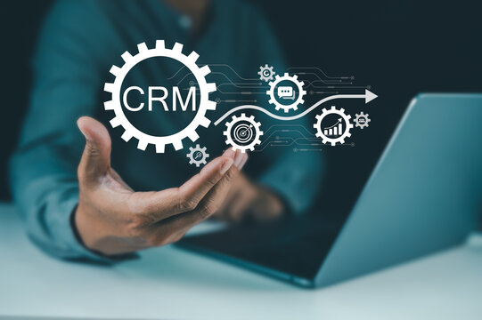A person holding a digital interface with CRM and gear icons representing customer relationship management and automation.