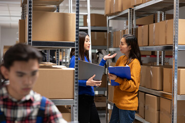 Asian staff members checking parcels at a startup fulfillment center. Local delivery and in house...