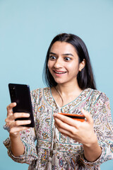 Joyous woman excited to purchase products with her credit card digits, adding payment method on...