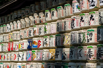 Straw-wrapped sake barrels stacked as offerings at Meiji Jing