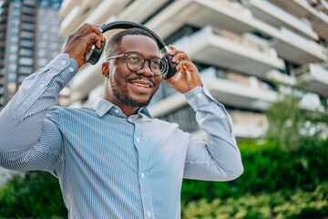 Confidence and style in urban landscape as black businessman enjoys music in modern city