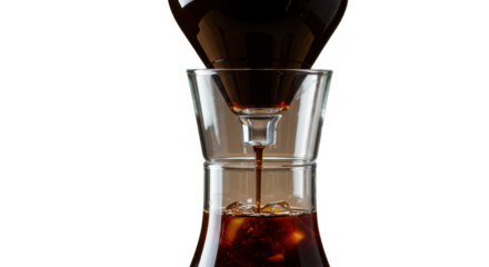 Coffee brewing in glass carafe with dark liquid dripping down  