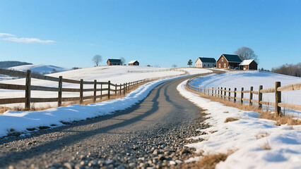 Winding country road through a snow covered farm landscape with wooden fence