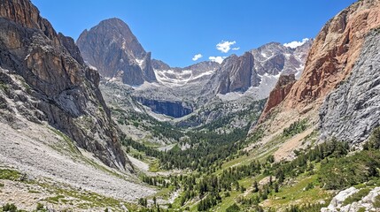 Majestic mountain valley with towering peaks, rocky slopes, and lush green vegetation. A serene landscape under a clear blue sky