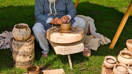 Traditional Potter Working with Clay on a Wooden Wheel. Old Style Pottery Making with Handcrafted...