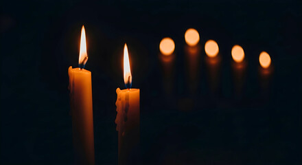Two burning candles on dark background
