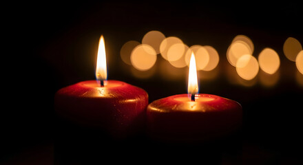 Two burning candles on dark background