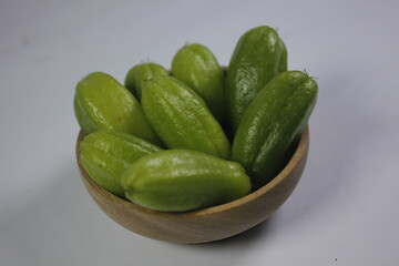 a curly-haired woman in a white dress looking at a laptop