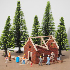 Mini toy of people and house at table with blurred background. Architect concept design. Miniature...