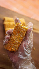 Jakarta, Indonesia 30 June 2025 : Hand holding a fried cheese roll with gooey cheese dripping....
