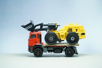 Mini toy of heavy truck and mini figure at table with blurred background. Miniature photography concept design.