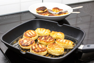 Traditional Russian sweet syrniki cottage cheese pancakes in the frying pan