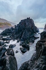 Dramatic Volcanic Rock Formation and Sea Stack on Sao Jorge Azores Coastline. Black basalt rocks,...