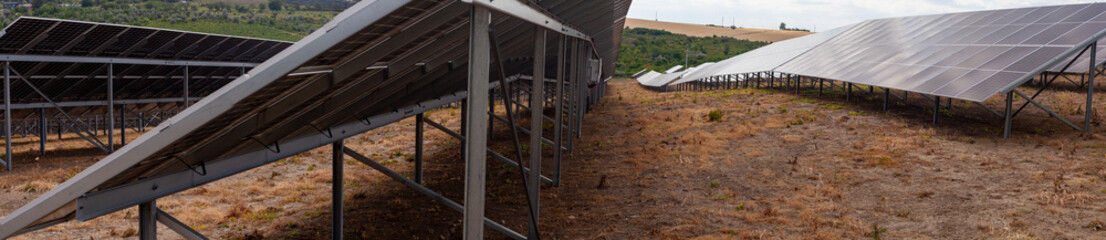 Large solar power station in dry countryside, rows of photovoltaic panels mounted on metal...